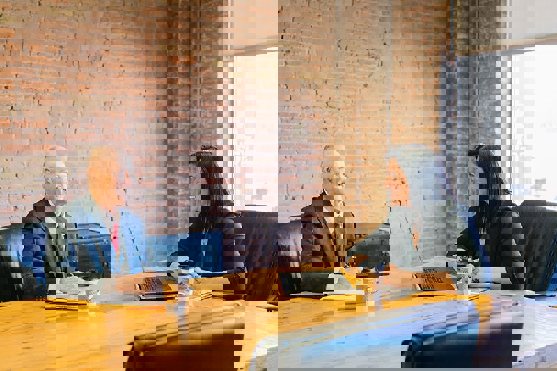 Man and Woman in board room having a meeting in person and smiling